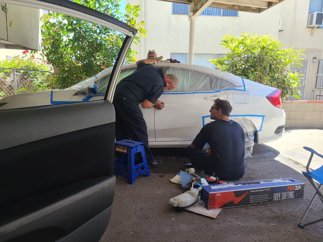 picture of a mechanic doing autobody work on a car