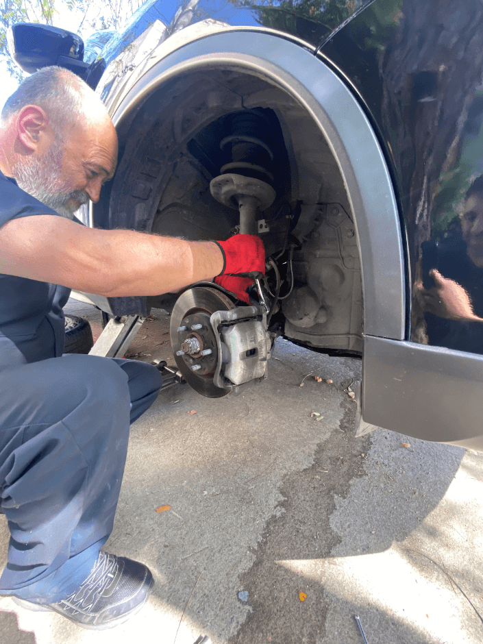 picture of a mechanic working on replacing brakes and rotors in a car